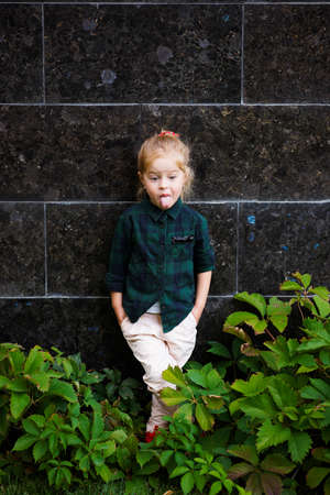 funny girl showing her tongue in streetの写真素材