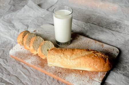 Still life of a glass of milk and sliced breadの写真素材
