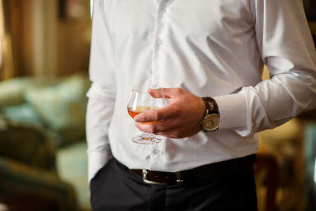 A man holds a glass of cognacの写真素材