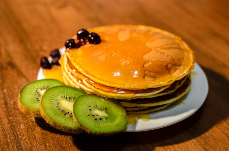 Delicious pancakes with honey, kiwi and berriesの写真素材