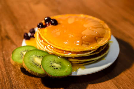 Delicious pancakes with honey, kiwi and berriesの写真素材