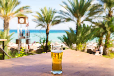 A glass of beer against the seaの写真素材