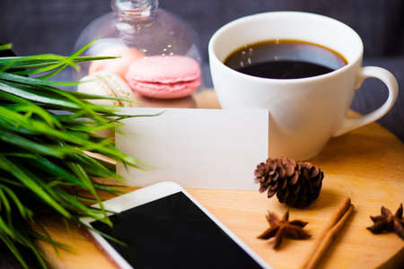 Office desk table with smartphone, pen on notebook, name card, cup of coffee and flower. top view with copy spaceの写真素材