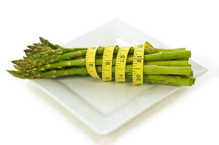Fresh asparagus with tape measure to reflect healthy diet for weight controlの写真素材