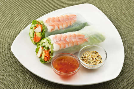 Fresh healthy prawn and salad sushi roll with sweet chili dipping sauce and sesame seeds