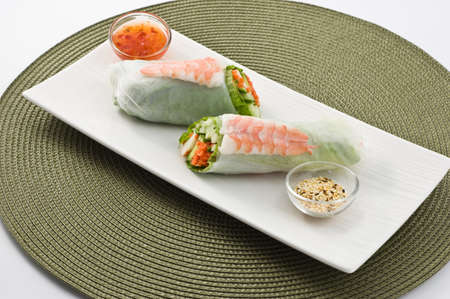 Fresh healthy prawn and salad sushi roll with sweet chili dipping sauce and sesame seeds