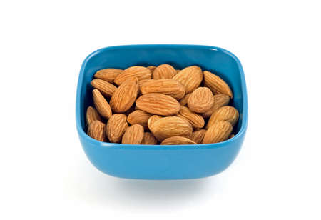 Raw whole almonds in blue plastic dish isolated on white backgroundの写真素材