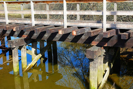 Old railway trestle reclaimed as public footbridge over riverの写真素材