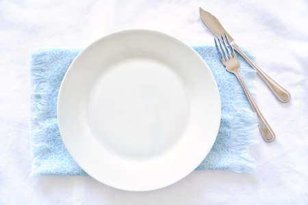 Empty round white plate on blue and white background in flat lay compoosition.  Blank area for your text. の写真素材