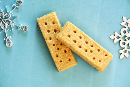 All butter shortbread fingers on aqua background in horizontal format in flat lay format.