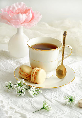Dainty china with tea and macaroons in vertical format.  Self care concept.の写真素材