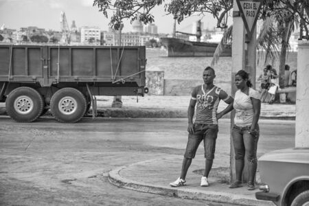Havana, Cuba - 12 January 2013: A view of the streets of the city with cuban people. Two afro-cuban teenagers waiting.のeditorial素材