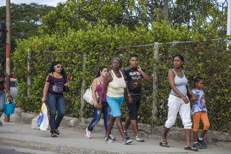 Havana, Cuba - 12 January 2013: A view of the streets of the city with cuban people. Several people walk on the pedestrian path.のeditorial素材