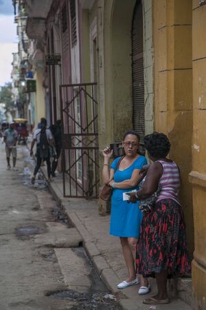 Havana, Cuba - 21 January 2013: A view of the streets of the city with cuban people. Two older women are talking.のeditorial素材