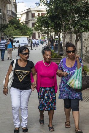 Havana, Cuba - 22 January 2013: A view of the streets of the city with cuban people. Three older women go and talk.のeditorial素材
