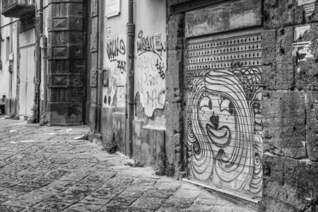 Naples, Italy - August 08, 2015 : Narrow streets of Naples, black and white photographs. View on graffiti on the garage door.のeditorial素材