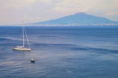 Naples, Sorrento Italy - August 10, 2015 : A view of the sea with the ships and Mount Vesuvius in the background. A big yacht in the foreground without sailing.のeditorial素材