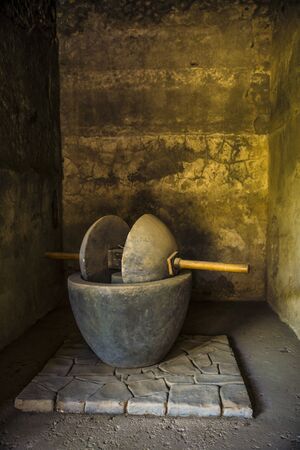 POMPEII, ITALY - 8 August 2015: Ruins of antique roman temple in Pompeii near volcano Vesuvius, Naples, Italy. A hand mill for cereals.のeditorial素材