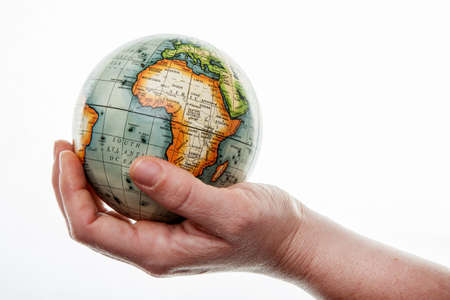 Hands hold the globe on a white background.の写真素材