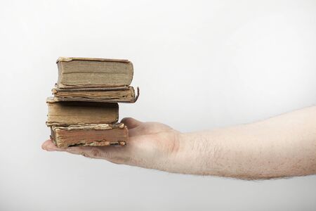 Male hand holds an antique books, isolated  on the white background.の写真素材