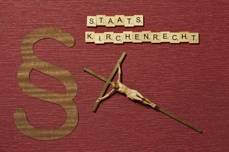 The sign paragraph on the claret color background. Its on the table. Word in german...