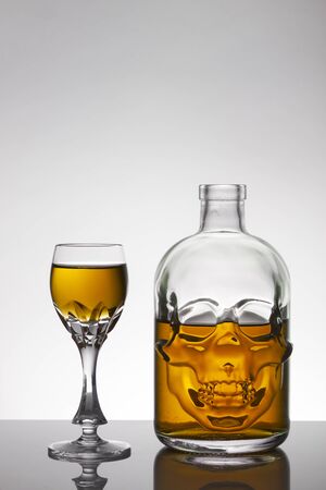 A skull bottle and crystal glasses with a liquid, alcohol drink.
Colored watery drink absinthe, curacao, cognac.の写真素材