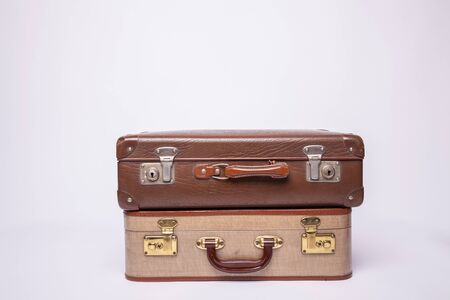 Old, retro, suitcases lie on the table with white background. Obsolete suitcase isolated on white backgroundの写真素材