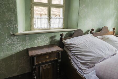 Bad Windsheim, Germany - 16 October 2019: Interior views of a german village house. View into the rural bedroom with colorful wallpaper and antique bedのeditorial素材