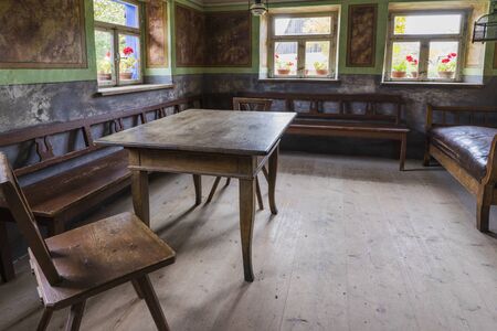 Bad Windsheim, Germany - 16 October 2019: Interior views of a german village house. View from an old rustic wooden dining table, chairs and benchesのeditorial素材