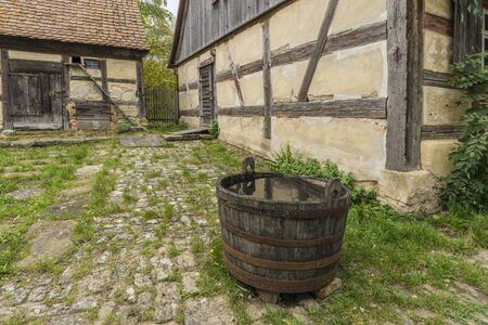Bad Windsheim, Germany - 16 October 2019: View from a half timbered house in a german village. A barrel full of rainwater in the foregroundのeditorial素材
