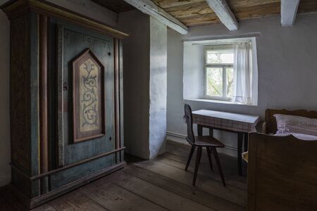 Bad Windsheim, Germany - 16 October 2019: Interior views of a german village house. View into the rural bedroom with table, chair, antique bed and wardrobeのeditorial素材
