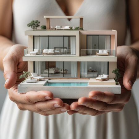 The image of a model house held in hands symbolizes the dream of home ownershipの素材