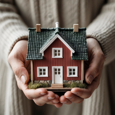 The image of a model house held in hands symbolizes the dream of home ownershipの素材