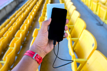 mobile phone and power bank in sport stadiumの写真素材