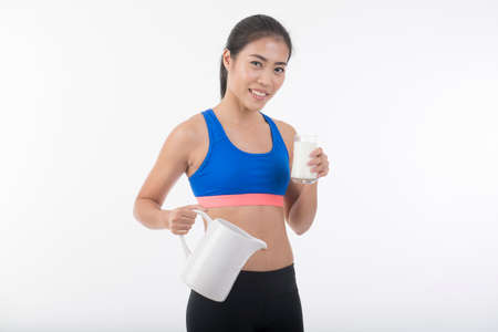 Cute healthy woman is drinking milk from a big glassの写真素材