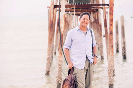 Asian male tourist standing at old wooden bridgeの写真素材