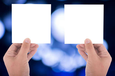 hand hold blank square paper over blur backgroundの写真素材