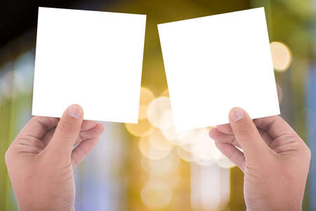 hand hold blank square paper over blur backgroundの写真素材