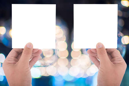hand hold blank square paper over blur background