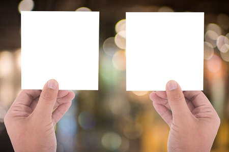hand hold blank square paper over blur background