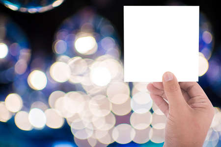 hand hold blank square paper over blur backgroundの写真素材