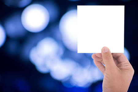 hand hold blank square paper over blur backgroundの写真素材