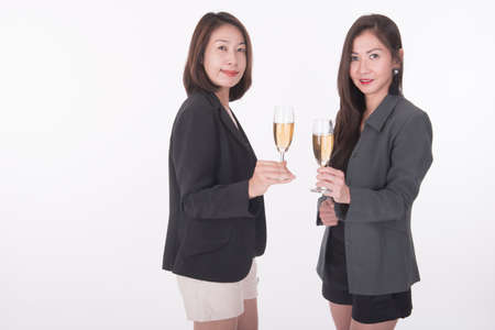 two asian business woman celebrate with champagneの写真素材