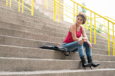 portrait of asian woman sitting on out door stairの写真素材