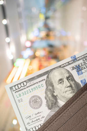 leather wallet with 100 dollar bills over colorful backgroundの写真素材