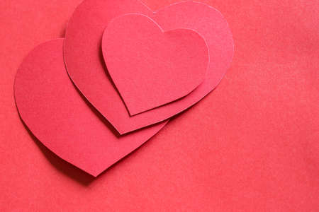 red paper hearts on red paper