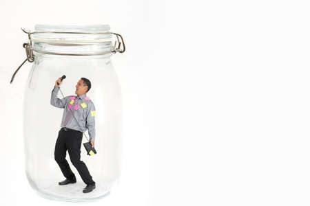 man standing inside glass bottle with telephoneの写真素材