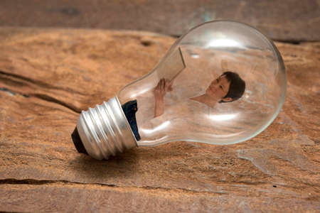 woman using computer tablet in bulb on wood floorの写真素材