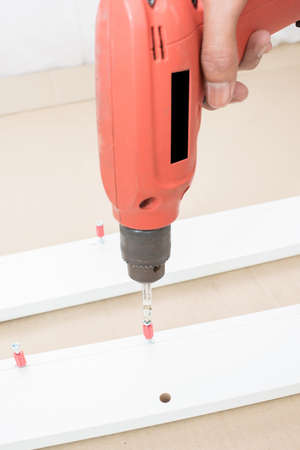 carpenter using Screwdriver assemble furniture
