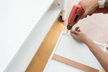 carpenter using Screwdriver assemble furniture